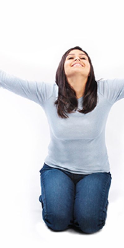 Young woman on her knees with arms raised up